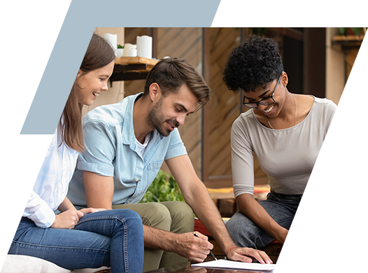 Photo of a couple reviewing a lease with the property manager.